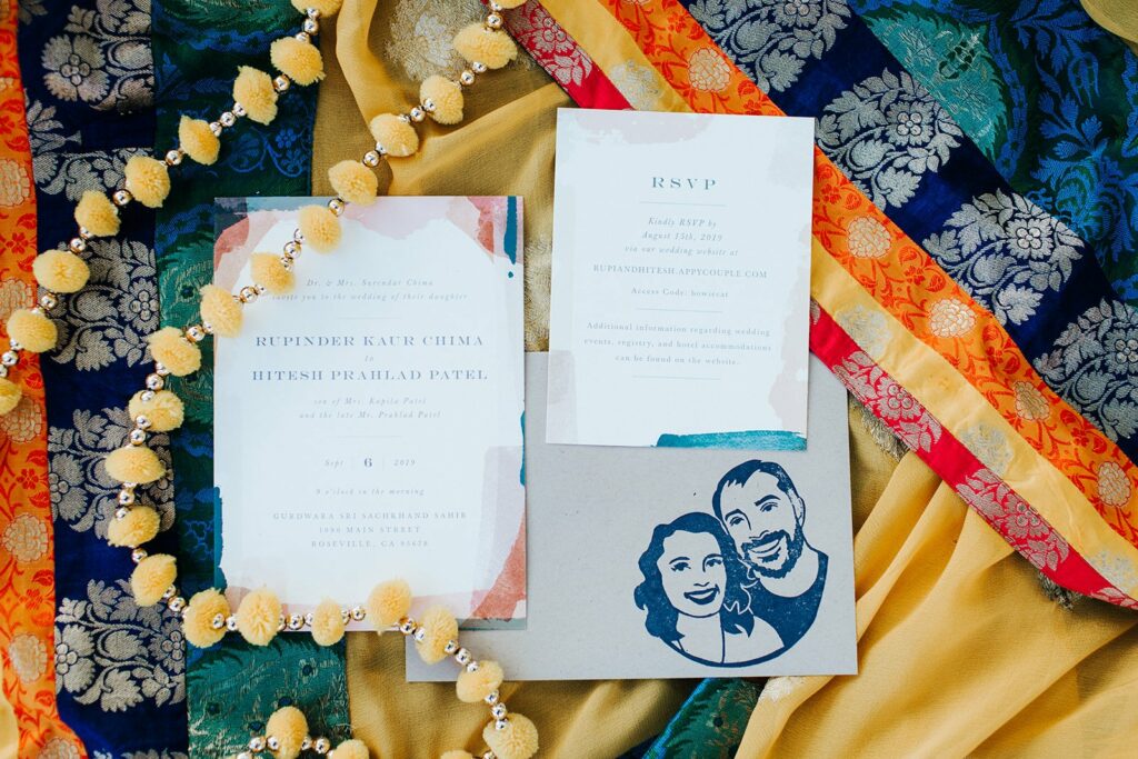 Wedding invitation set with RSVP card, a portrait of a couple, and colorful fabric with decorative patterns in the background.
