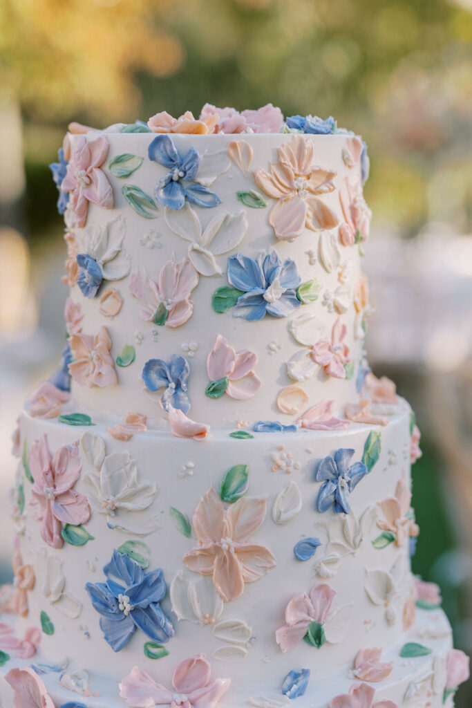 Three-tiered cake decorated with pastel-colored floral icing.