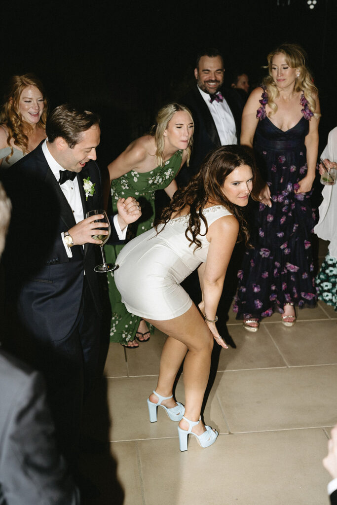 People dressed formally enjoy a lively dance moment at an event.