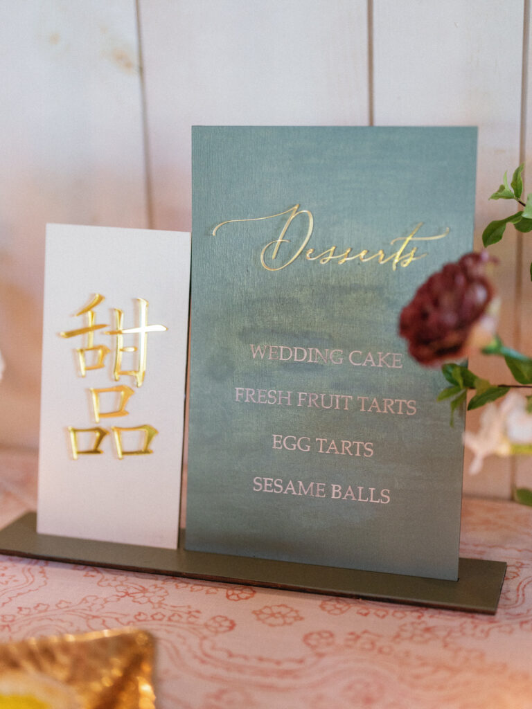 Menu card listing desserts: wedding cake, fresh fruit tarts, egg tarts, sesame balls. Decorative gold text and floral accents.