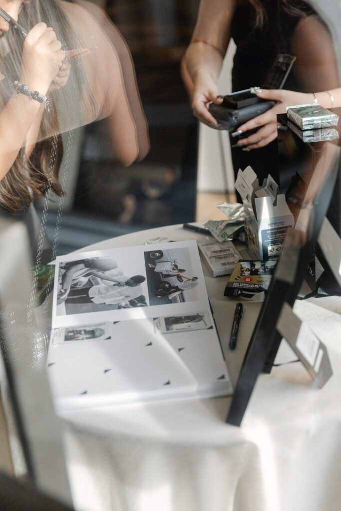 People interacting at a table with photos and stationery.